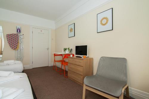 a bedroom with a bed and a chair and a desk at The Jollys in Bootle