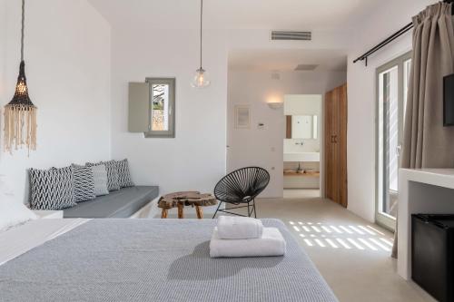 a white room with a bed and a couch at Trinity Mykonos - Beachfront Villa in Platis Yialos Mykonos