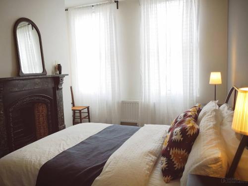 a bedroom with a bed and a mirror and windows at Homely Serviced Apartments - Figtree in Sheffield