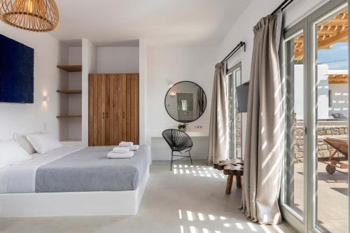 a bedroom with a bed and a mirror at Trinity Mykonos - Beachfront Villa in Platis Yialos Mykonos