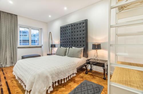 a bedroom with a large bed and a window at Marquês de Pombal Metropolitan Flat in Lisbon