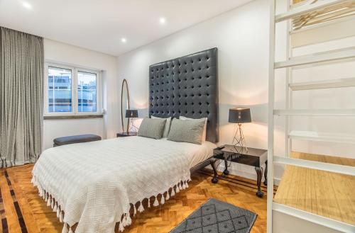 um quarto com uma cama grande e uma janela em Marquês de Pombal Metropolitan Flat em Lisboa