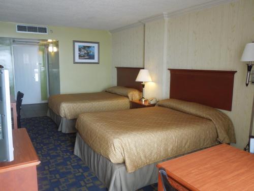 a hotel room with two beds and a table at Seahawk Motel in Virginia Beach