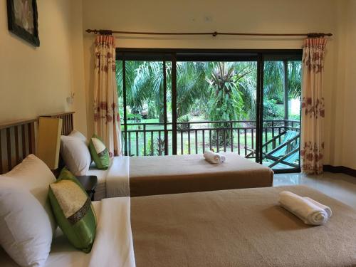 Kama o mga kama sa kuwarto sa Khao Sok Palm Garden Resort