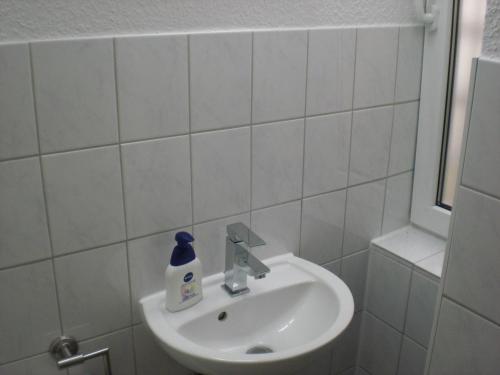 a white sink sitting under a mirror in a bathroom at Apartment Schulz in Berlin