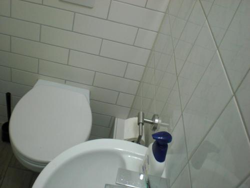 a white toilet sitting next to a white sink at Apartment Schulz in Berlin