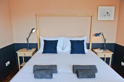 a bedroom with a large white bed with blue pillows at Expresso Martinis Mood Apartment 4C in Lisbon