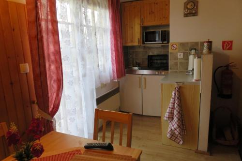a small kitchen with a table and a refrigerator at Holiday home at Aquapark Tatralandia in Liptovský Mikuláš