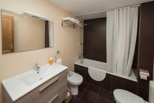 een badkamer met een wastafel, een toilet en een douche bij La Magacén. in Mora de Rubielos