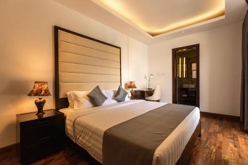 a bedroom with a large bed with a large headboard at Lavonca Boutique Hotel in Colombo