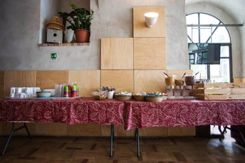 a table with a red table cloth on it at La Controra Hostel Naples in Naples