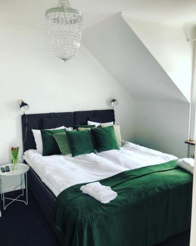 a bedroom with a large bed with green pillows at Hotell Taberg in Taberg