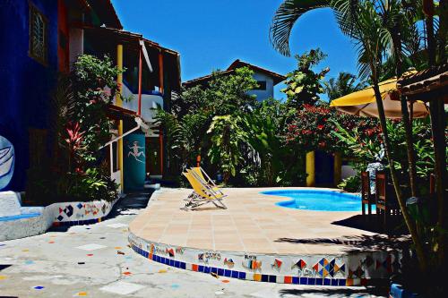 uma piscina com uma espreguiçadeira e uma piscina em Art Hotel Aos Sinos Dos Anjos em Arraial d'Ajuda