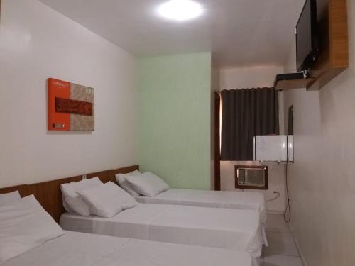 Postel nebo postele na pokoji v ubytování Ipê Guaru Hotel