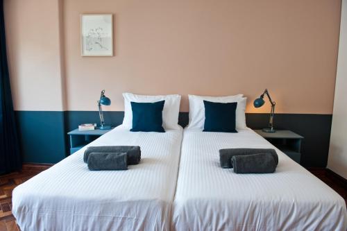 una camera con due letti con cuscini blu sopra di Prosecco is a Lifestyle Apartment 4B a Lisbona