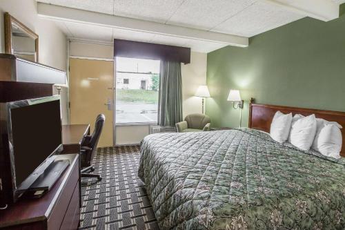 um quarto de hotel com uma cama e uma televisão de ecrã plano em Rodeway Inn em Laurens