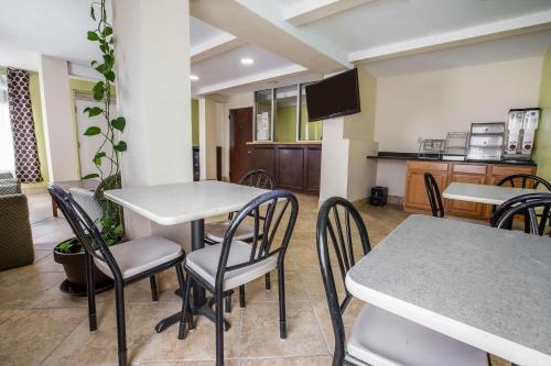 a dining room with tables and chairs and a kitchen at Rodeway Inn in Laurens
