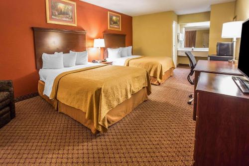 a hotel room with two beds and a desk at Quality Inn Gaffney I-85 in Gaffney