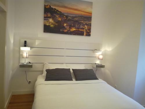 リスボンにあるFlor Lizのベッドルーム1室(白いベッド1台、枕2つ付)
