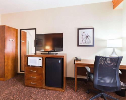a hotel room with a desk with a tv and a computer at Econo Lodge Inn & Suites East Houston I-10 in Houston