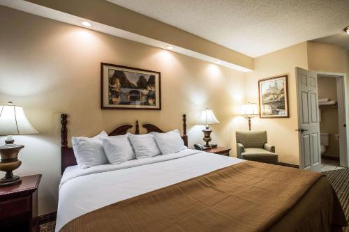 a hotel room with a large bed and a chair at Quality Inn Kingsport South in Kingsport
