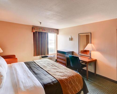 a hotel room with a bed and a desk at Quality Inn Forest Hill - Fort Worth South in Forest Hill