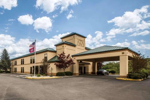 a large building with a flag in a parking lot at Quality Inn Rogersville in Rogersville
