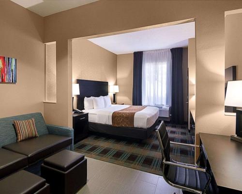 a hotel room with a bed and a couch at Comfort Suites Houston West at Clay Road in Houston