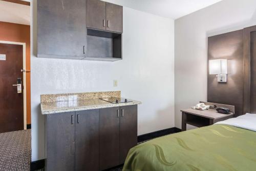 a hotel room with a bed and a kitchen at Quality Inn Warsaw near Rappahannock River in Warsaw
