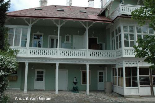a large green house with a balcony on top of it at Raisa Apartments Fünkhgasse in Pressbaum