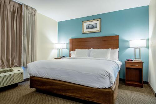 MainStay Suites Geismar - Gonzales في Geismar: سرير كبير في غرفة الفندق مع مصباحين