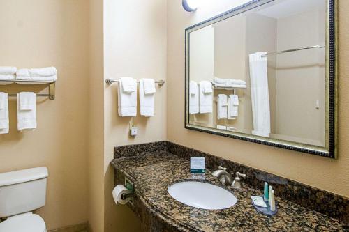 a bathroom with a sink and a toilet and a mirror at Quality Inn & Suites in Robstown