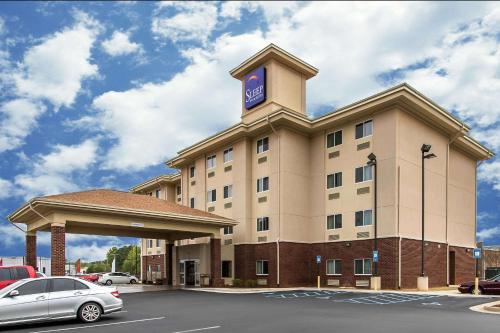 ein Hotelgebäude mit einer Uhr darüber in der Unterkunft Sleep Inn & Suites Huntsville near US Space & Rocket Center in Huntsville