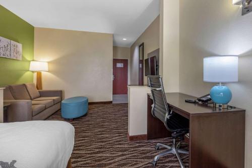 a hotel room with a bed and a desk with a computer at Sleep Inn & Suites Millbrook - Prattville in Millbrook
