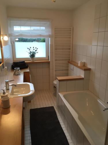 a bathroom with a tub and a sink at Ferienwohnung Hämelschenburg in Emmerthal