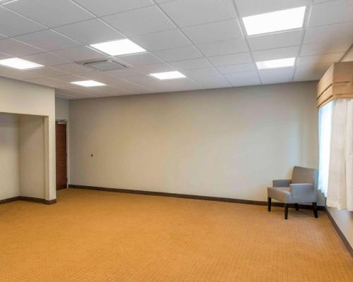 an empty room with a chair and a white wall at Sleep Inn & Suites Defuniak Springs - Crestview in Mossy Head