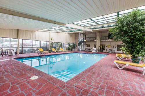 ein großer Pool mit Stühlen und Tischen in einem Gebäude in der Unterkunft Quality Inn in Tifton