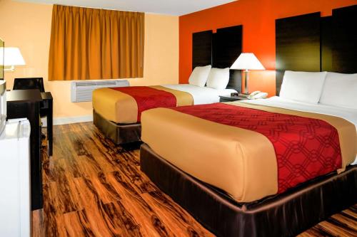 two beds in a hotel room with orange walls at Econo Lodge Rome in Rome