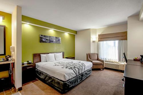 a hotel room with a bed and a chair at Sleep Inn Frederick in Frederick