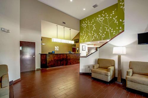 a living room with two chairs and a staircase at Sleep Inn Frederick - Ballenger Creek in Frederick