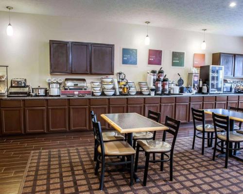 una cucina con armadi in legno, tavoli e sedie di Baymont by Wyndham Richmond I-70 a Richmond