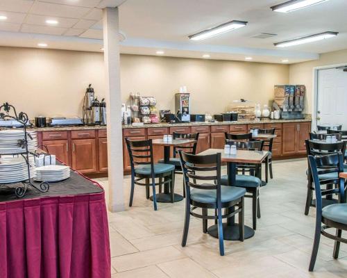 un restaurant avec des tables, des chaises et un comptoir dans l'établissement Clarion Inn I-94 near Expo Center, à Kalamazoo