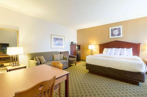 une chambre d'hôtel avec un lit et un canapé dans l'établissement Quality Inn Fairmont, à Fairmont
