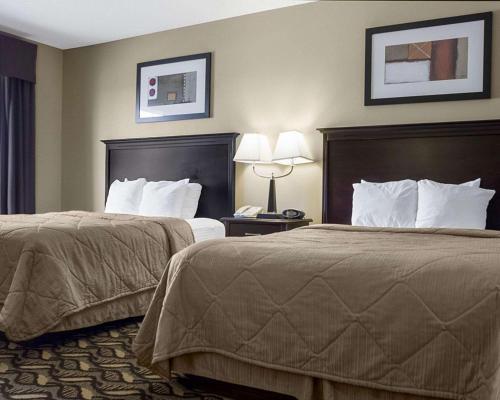 um quarto de hotel com duas camas e duas lâmpadas em MainStay Suites Bismarck em Bismarck