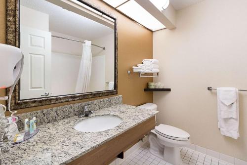 a bathroom with a sink and a toilet and a mirror at Quality Inn Fairmont in Fairmont