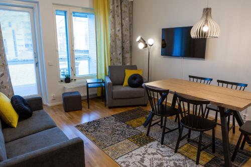 a living room with a table and a couch at Antintorni Apartment 14 in Pori