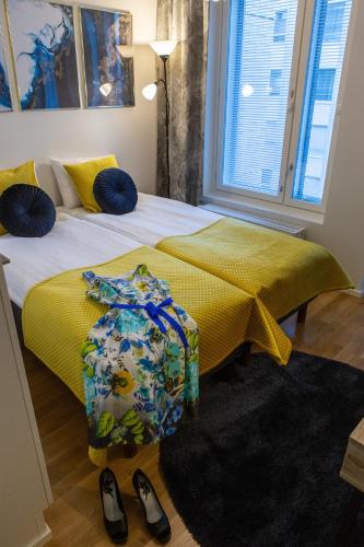 a bedroom with two beds with yellow sheets and blue pillows at Antintorni Apartment 14 in Pori