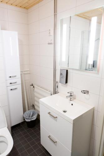 a white bathroom with a sink and a mirror at Antintorni Apartment 14 in Pori