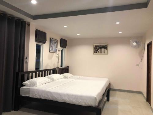 una camera da letto con un letto grande con lenzuola bianche di The Seaside Resort Koh Phangan a Wok Tum