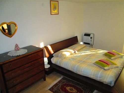 a bedroom with a bed with a dresser and a mirror at LA CASA DEI NONNI in Acqualagna